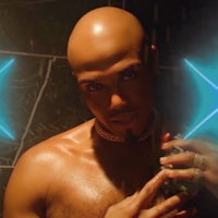 a bald man is holding a blue light in front of a mirror